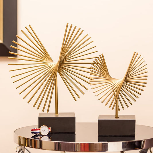 Two abstract geometric metal ornaments are displayed on the table.