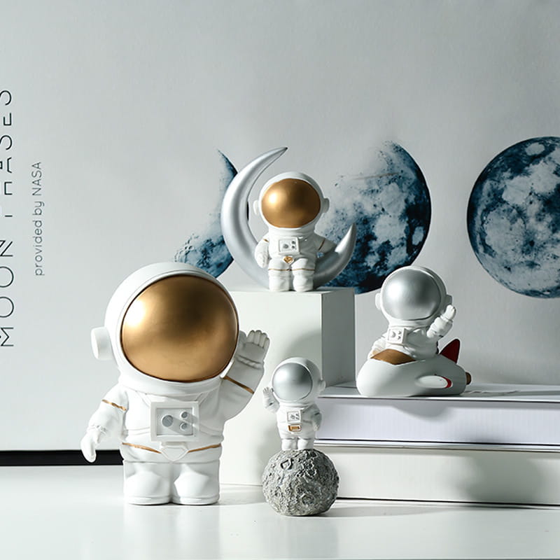 Four different types of astronaut decorations are displayed on the table.