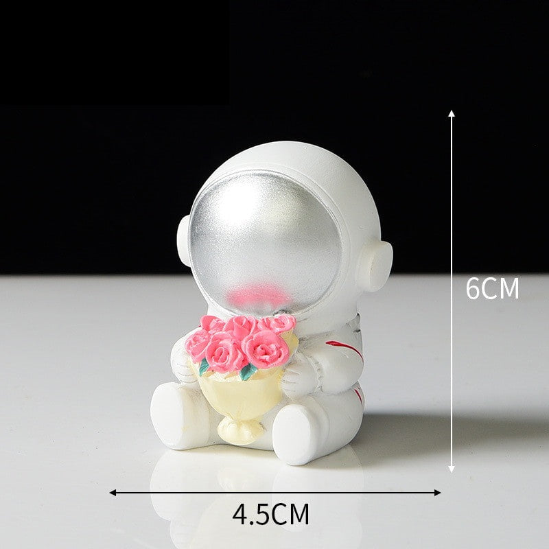 The style L Ornament is an astronaut wearing a silver visor carrying a bouquet of flowers in his arms.