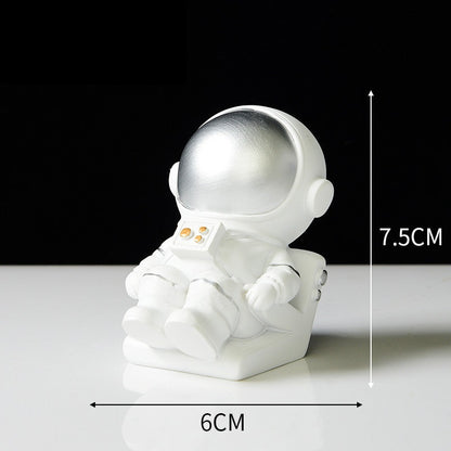 The style M Ornament is an astronaut wearing a silver visor lying on a recliner.