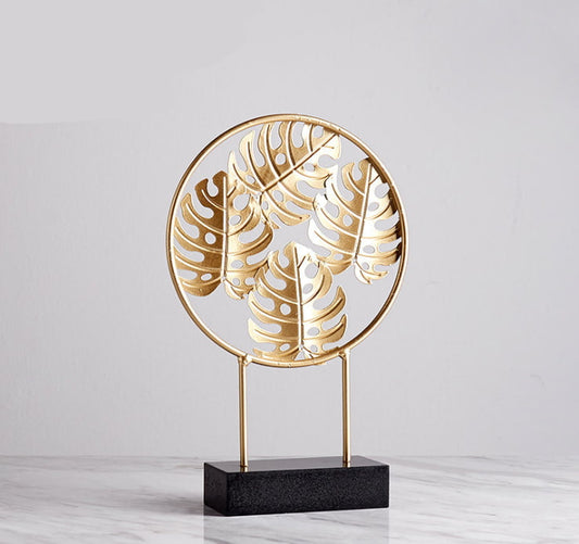 Small intricate gold metal turtle leaves sculpture on sleek black base, artistic and stylish.