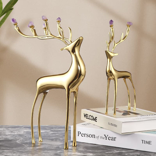 Two golden deer, their antlers with amethyst, were displayed on a marble table.