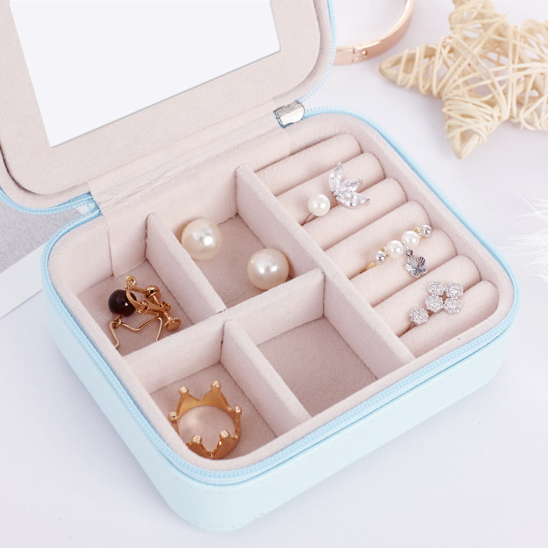 Close-up of interior for blue mini portable jewelry box with zipper closure.