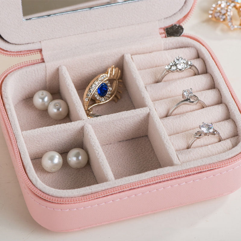 Close-up of interior for pink mini portable jewelry box with zipper closure.