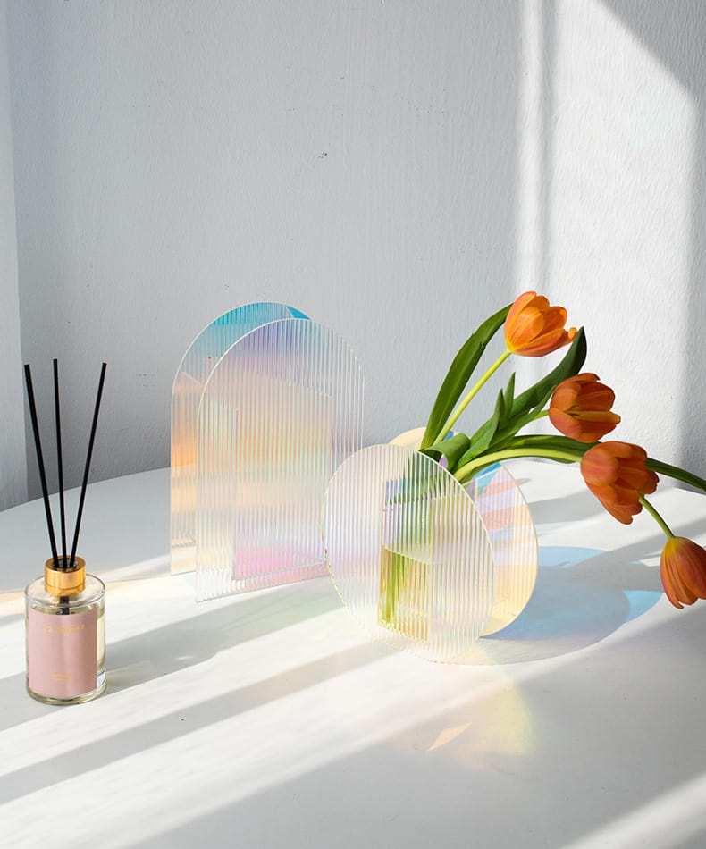 Arch and round modern colorful acrylic vase are displayed on the table.