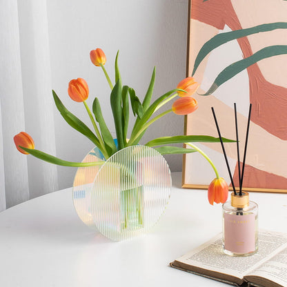 Round modern colorful acrylic vase is displayed on the table.