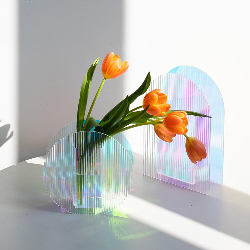 Arch and round modern colorful acrylic vase are displayed on the table.