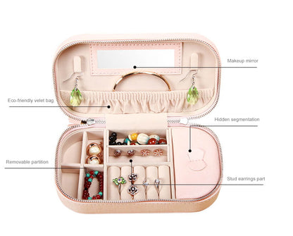 Details display for pink portable jewelry box designed with tassels and zipper closure.