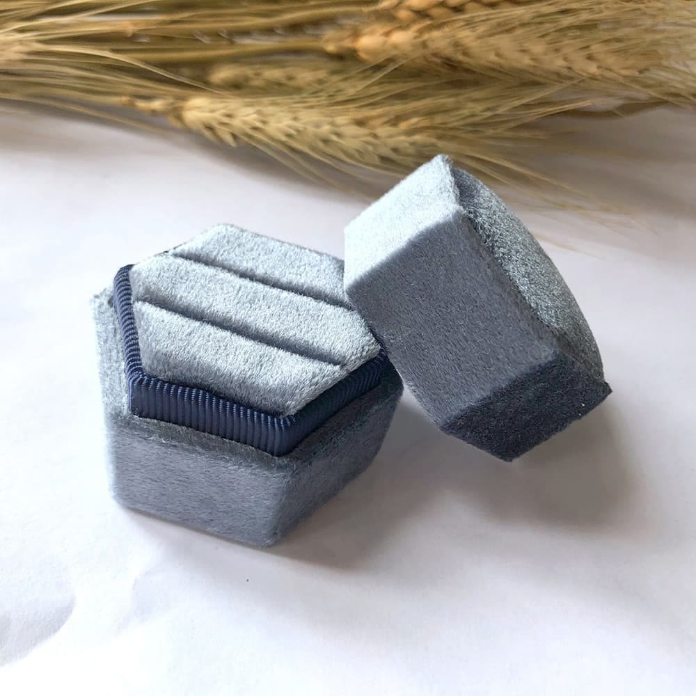 Grayish blue fine hexagon velvet ring box with double slot.