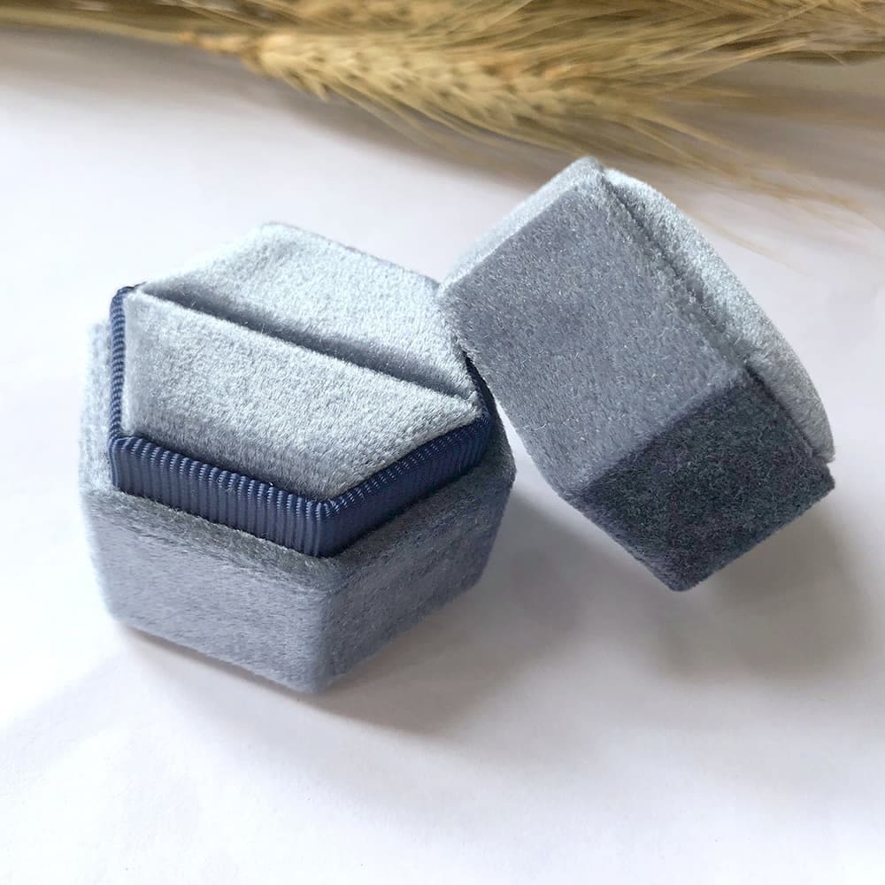 Grayish blue fine hexagon velvet ring box with single slot.