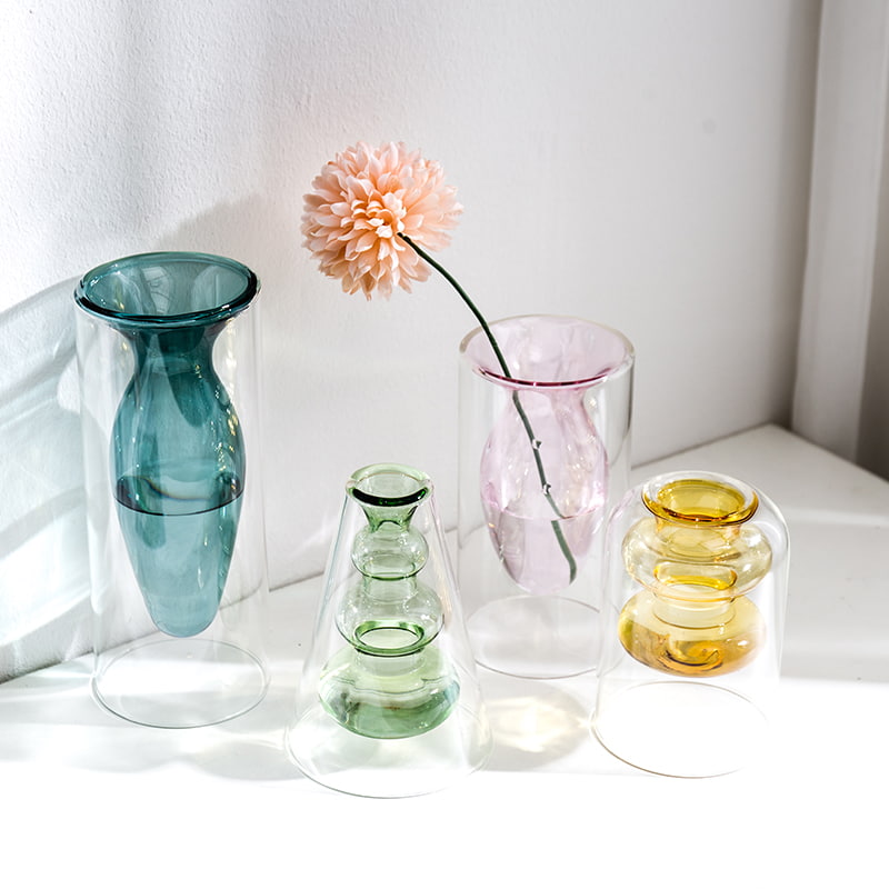 Display for yellowA and light green and light pink and peacock blue modern colored glass vase.