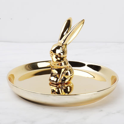 Golden ceramic jewelry tray, and a golden rabbit sitting on the middle of the dish.