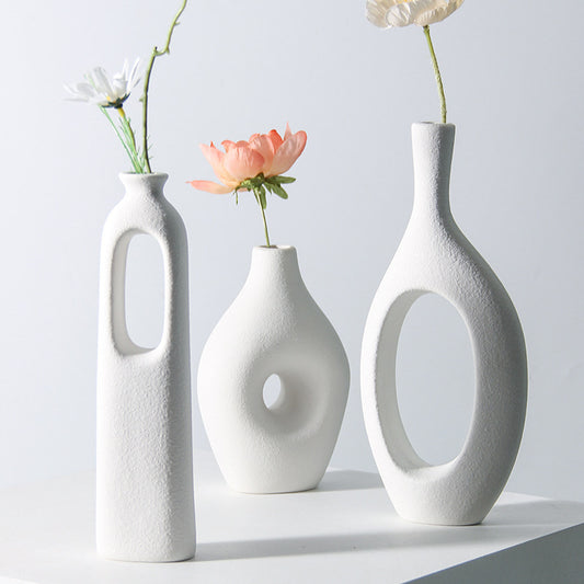 Display for A and B and D white circle ceramic vase.